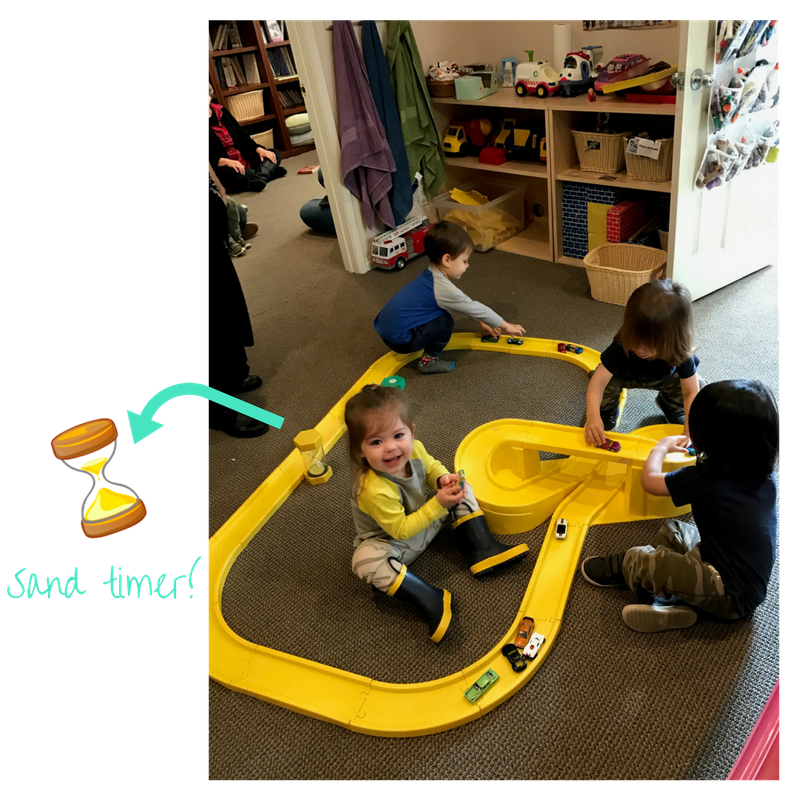 kids playing and learning to share using with sand timer at early childhood development class