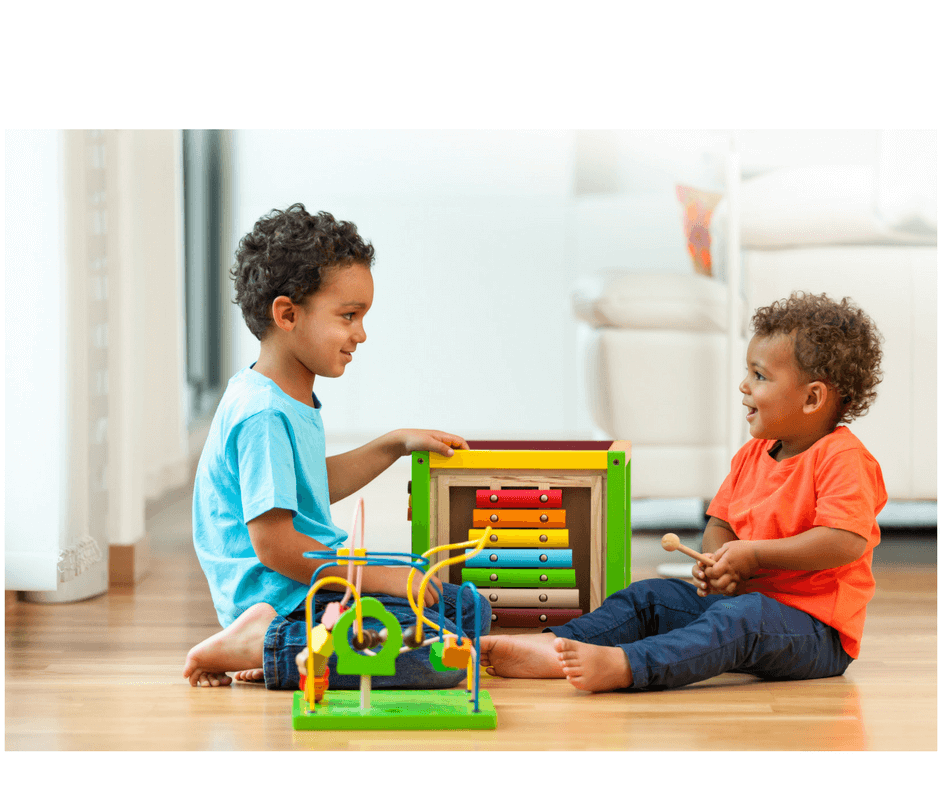 kids playing and learning to share using with sand timer at early childhood development class