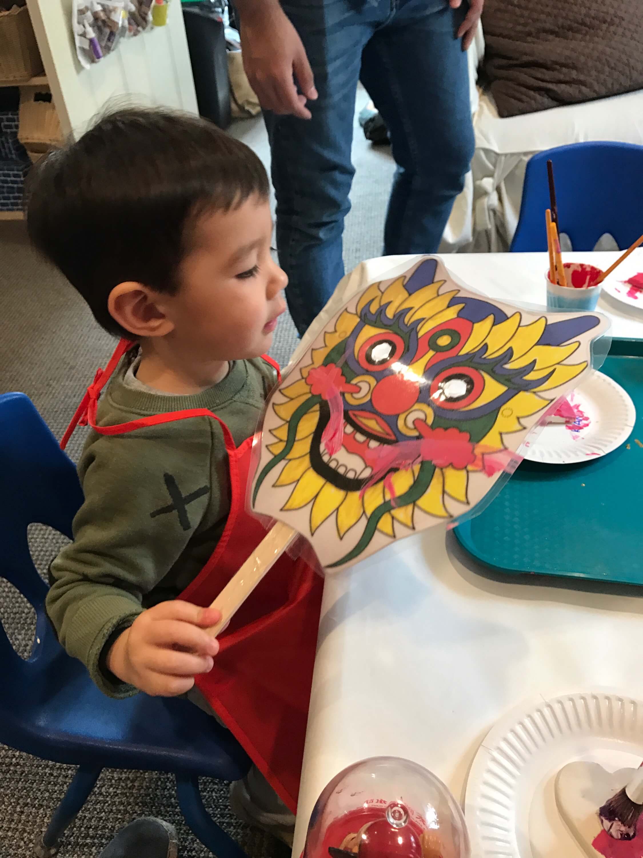 little boy holding chinese new year mask at early childhood development class