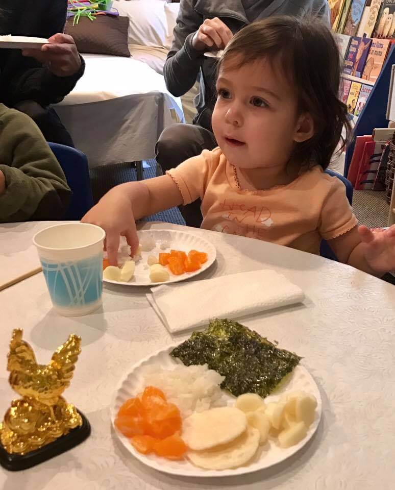 little girl eating chinese food at early childhood development class