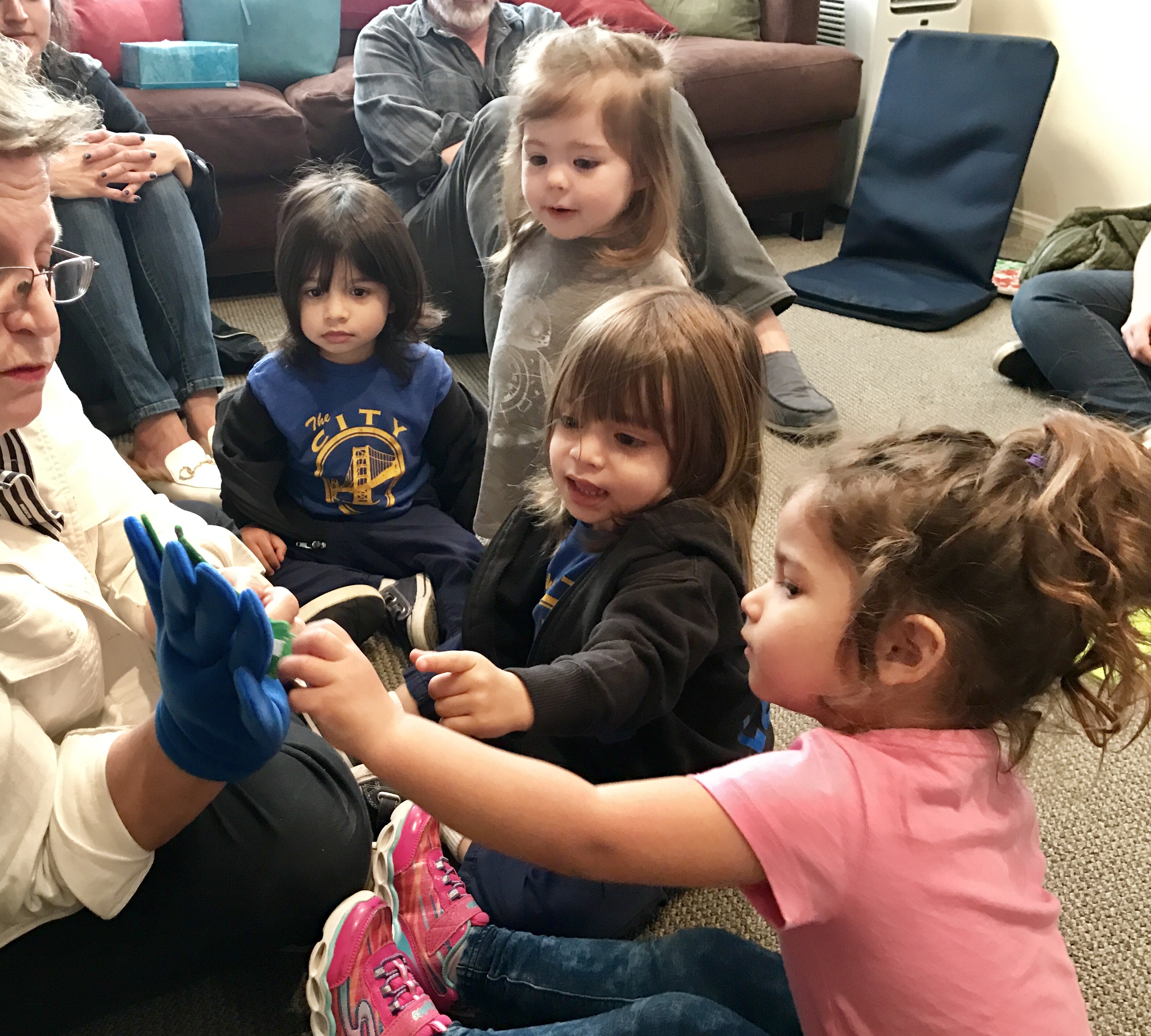 4 children learning with teacher at early childhood development class