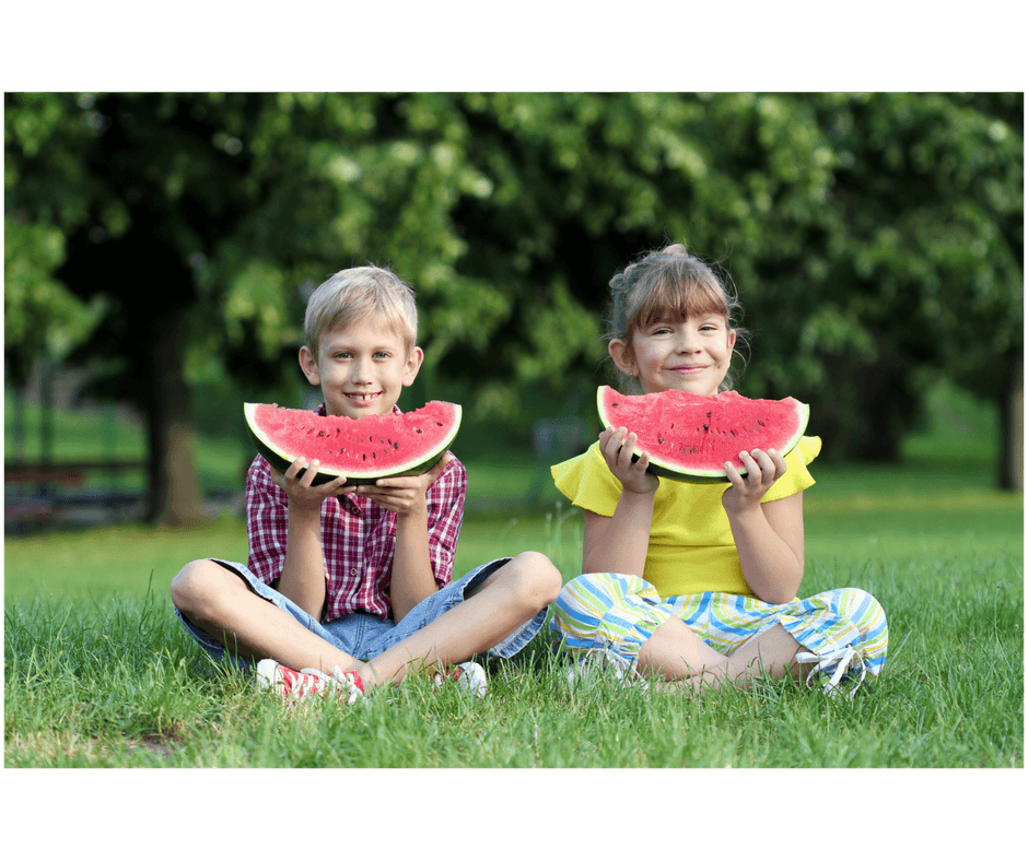 friends sitting side by side eating watermellon