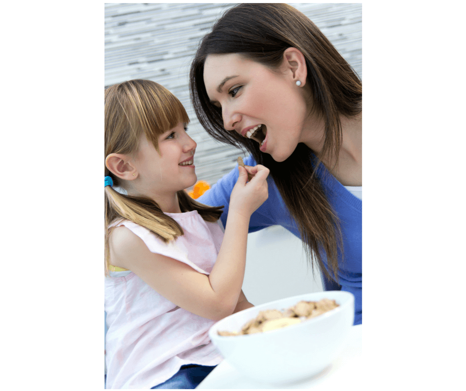 girl feeding mom healthy food