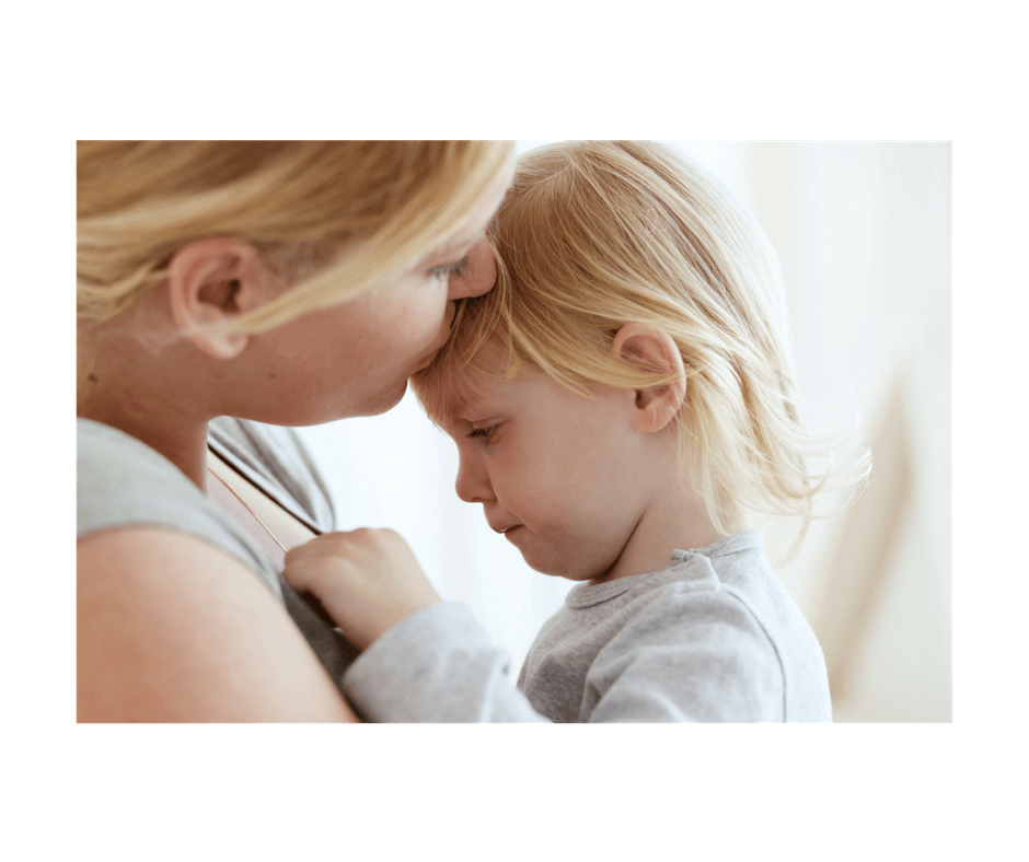 mother and toddler daughter, girl seems unhappy, mom is kissing her