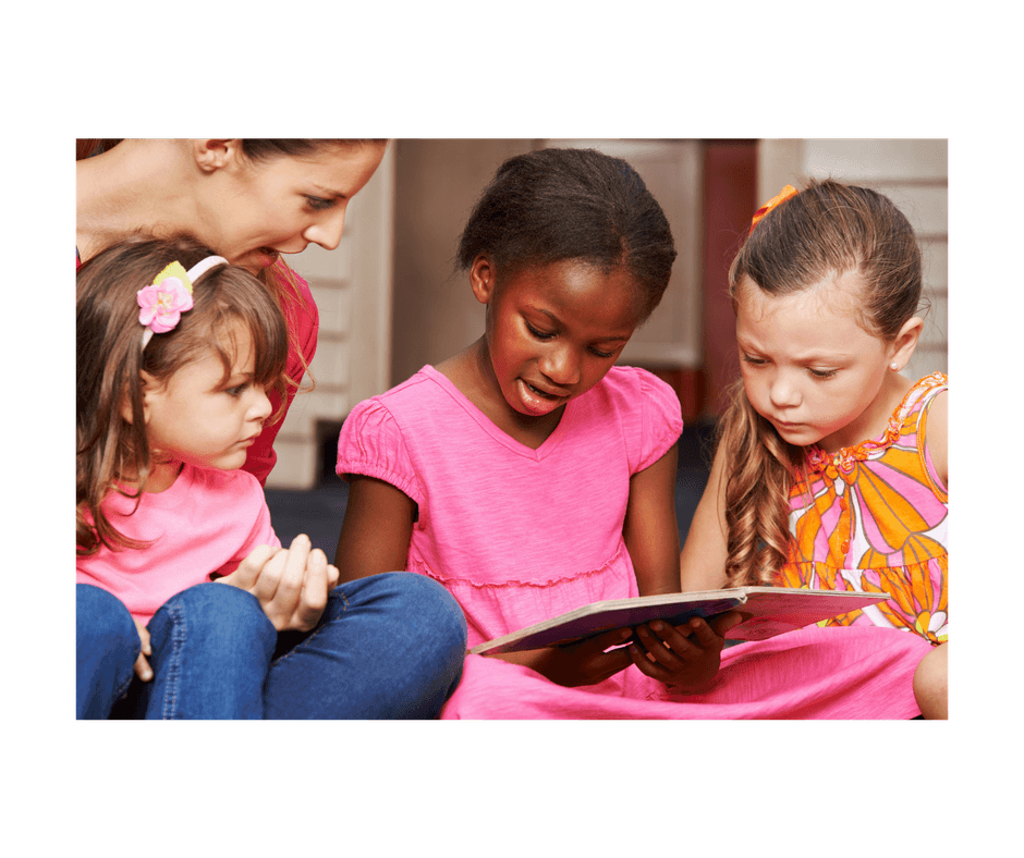 mom holding chil on her lap while other 2 children read a book