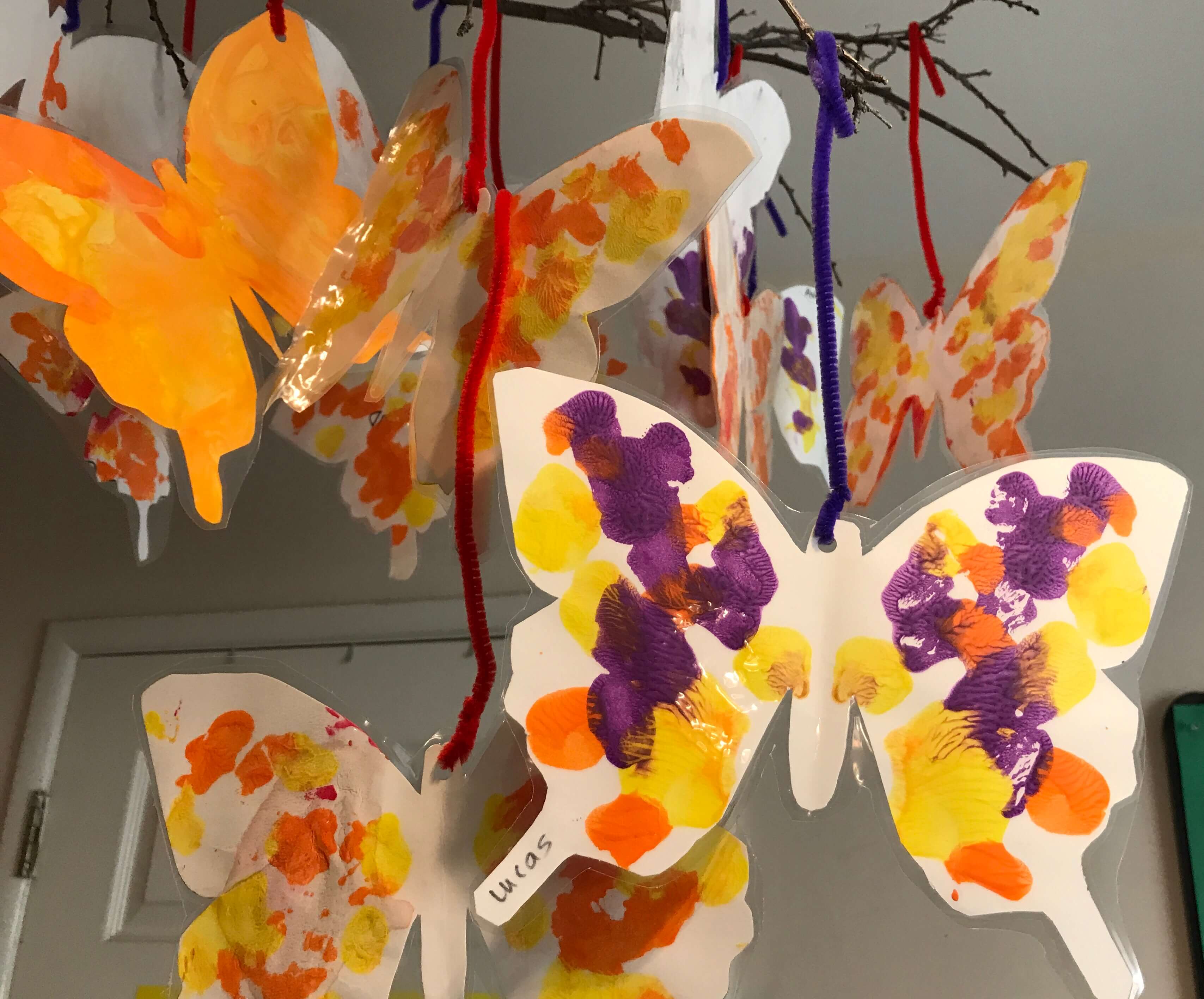 toddler painting butterfly shaped paper at early childhood development associates class