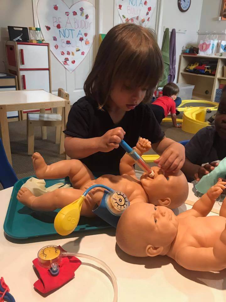 toddler playing with doctor kit at early childhood developmpent associates
