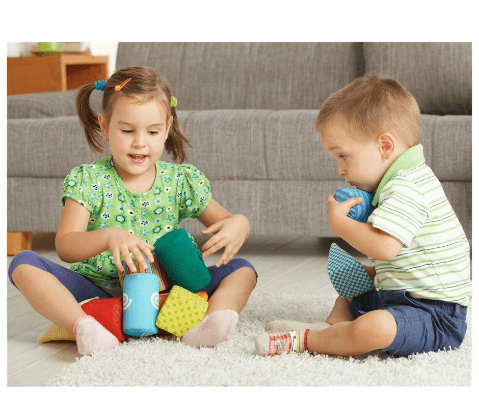 2 children playing together sharing toys