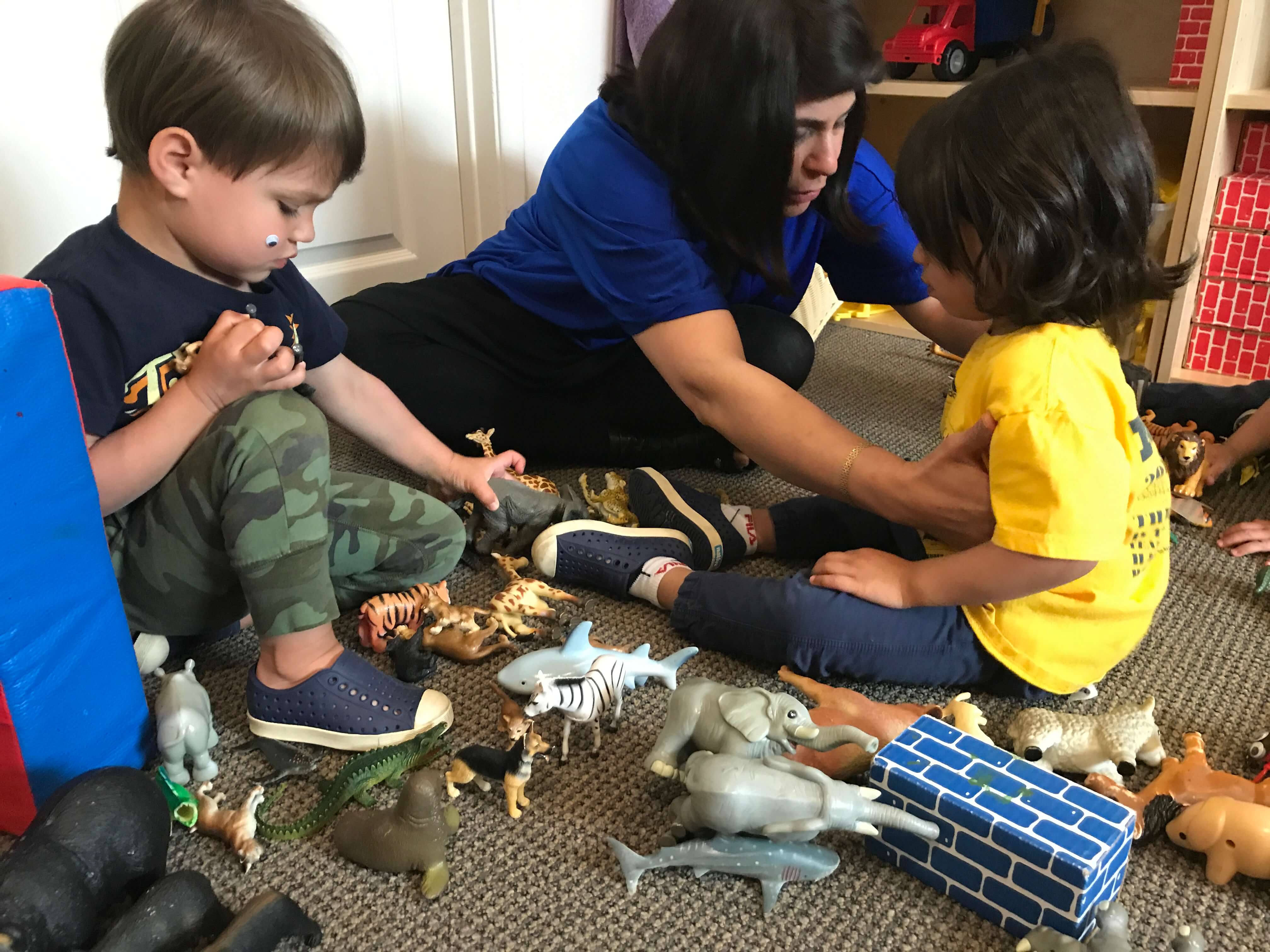 2 toddlers and teacher playing together sharing and taking turns at early childhood development associates