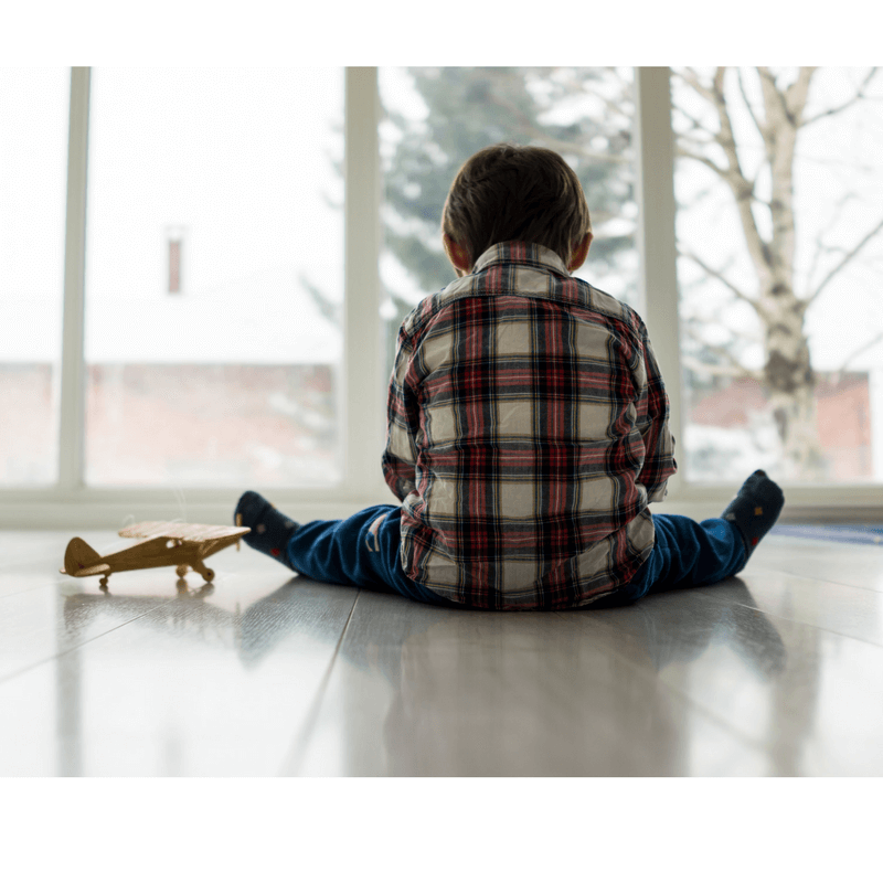 child facing window, seems lonely