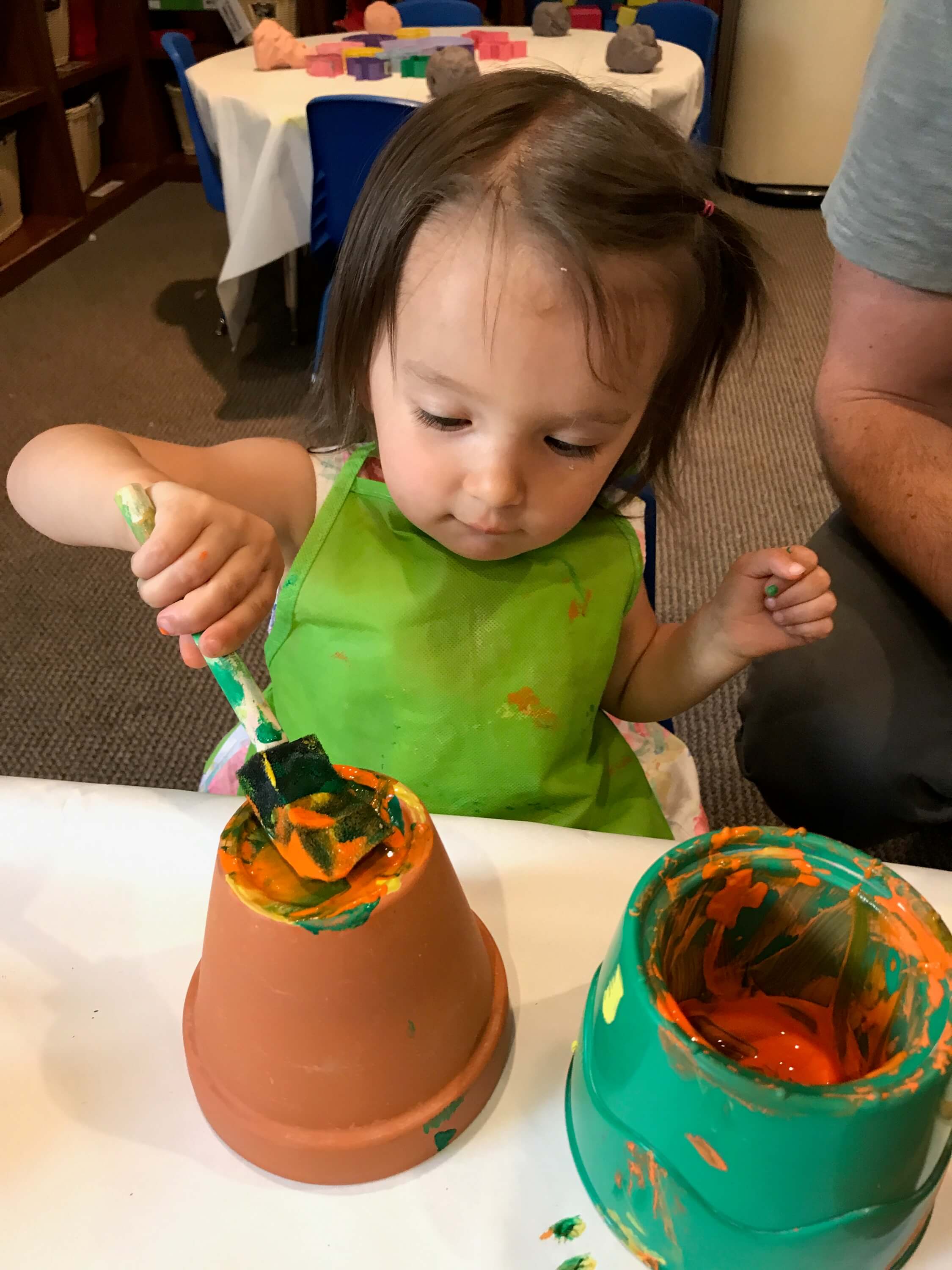 toddler paiting pot at early childhood development associates' class