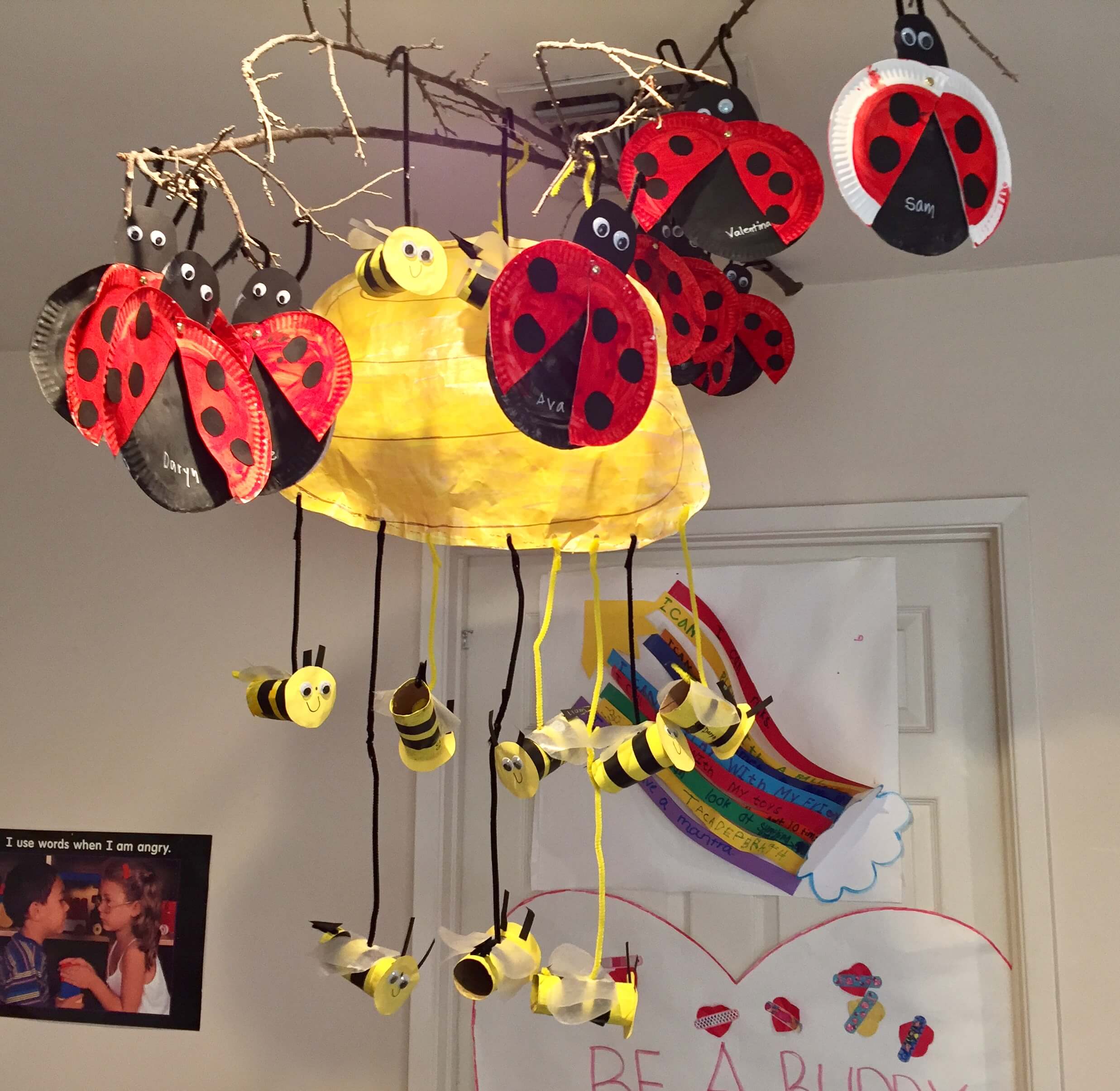 bugs made out of paper plates and toilet paper rolls hanging from ceiling at early childhood development associates