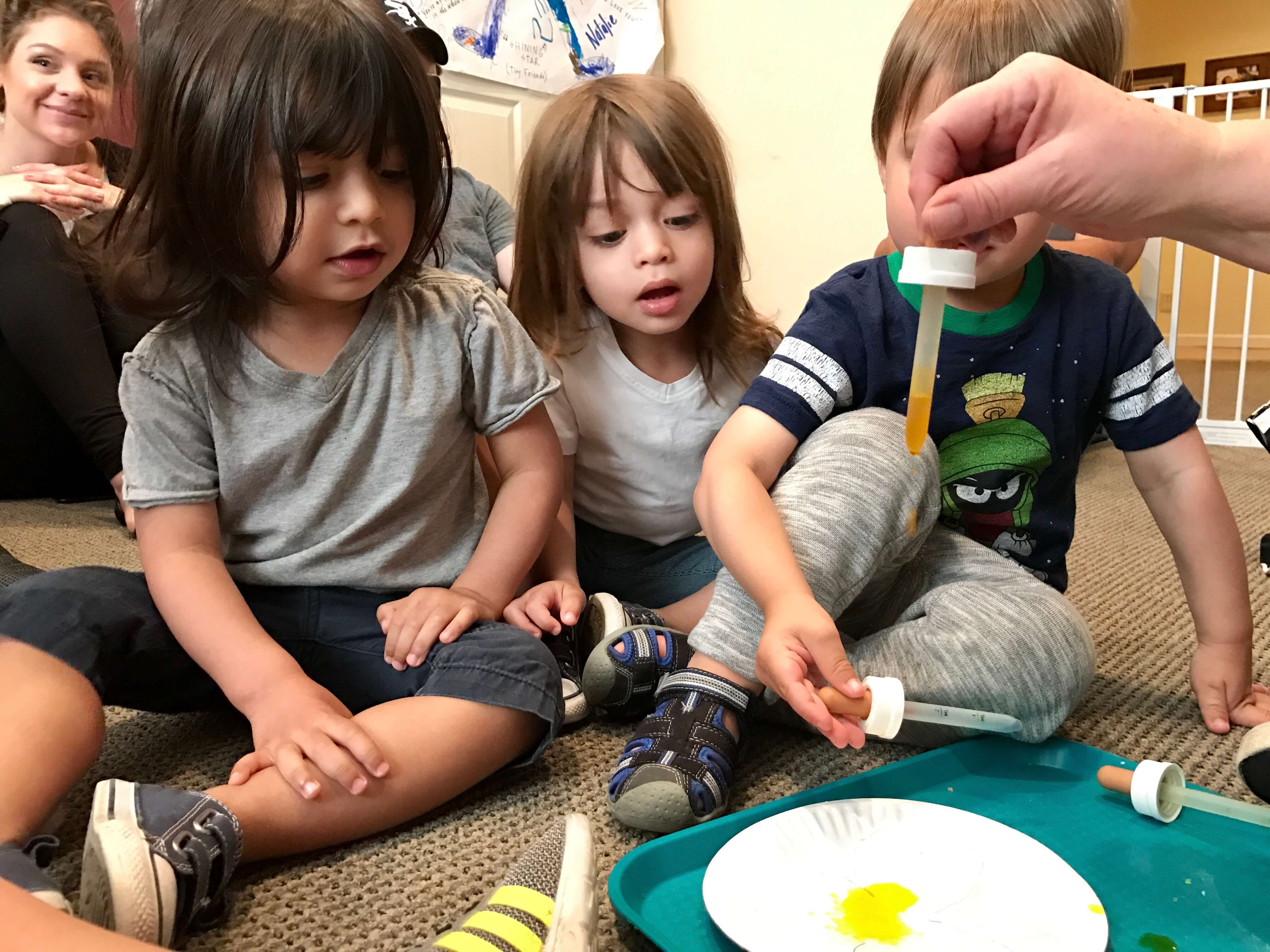 3 children learning to drop paint at early childhood dvelopment associates' class