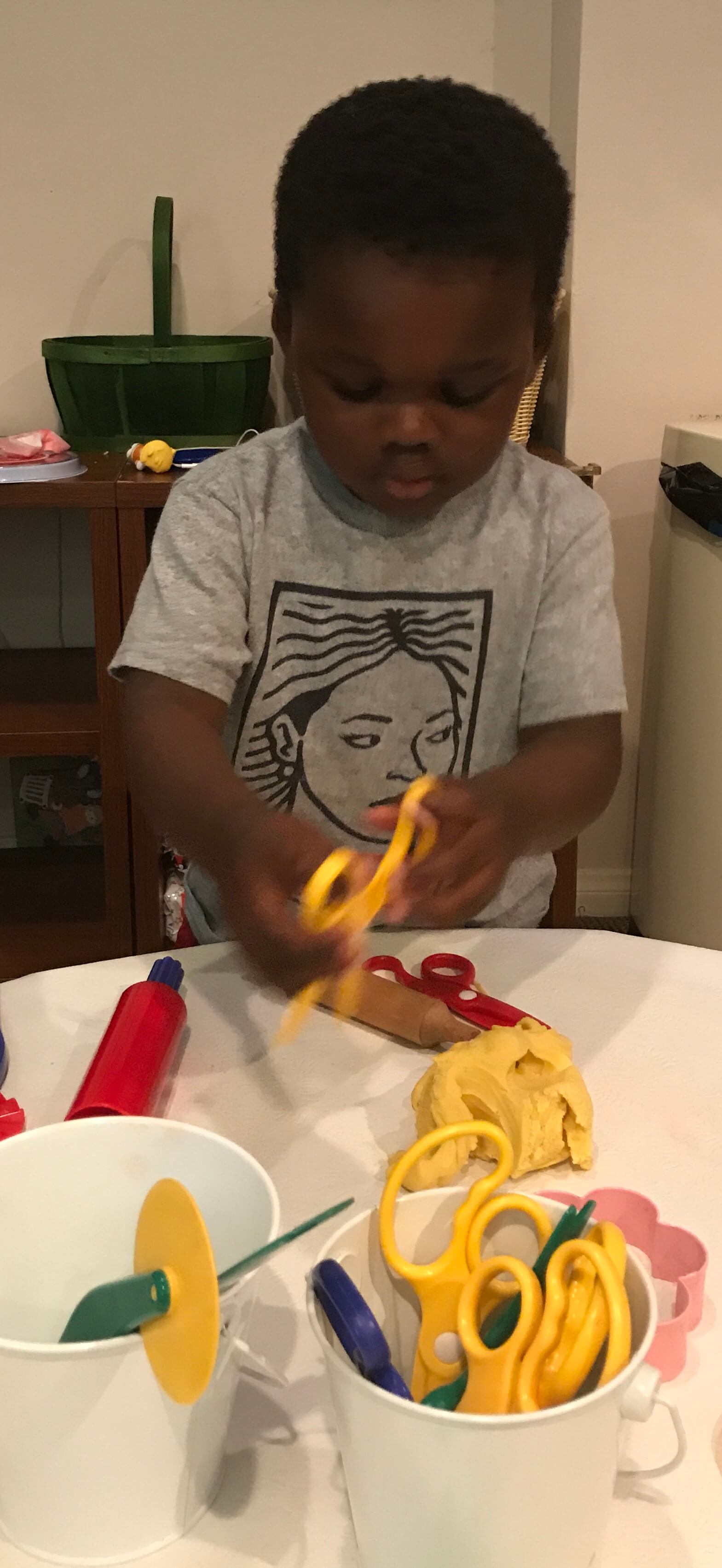 toddler using scissors at Early Childhood Development Associates' class