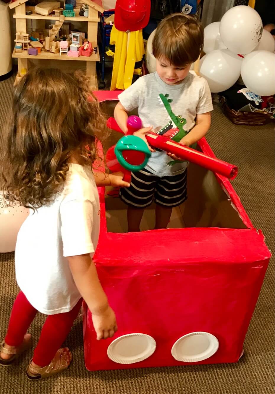 toddlers pretend playing inside firetruck at Early Childhood Development Associates' class