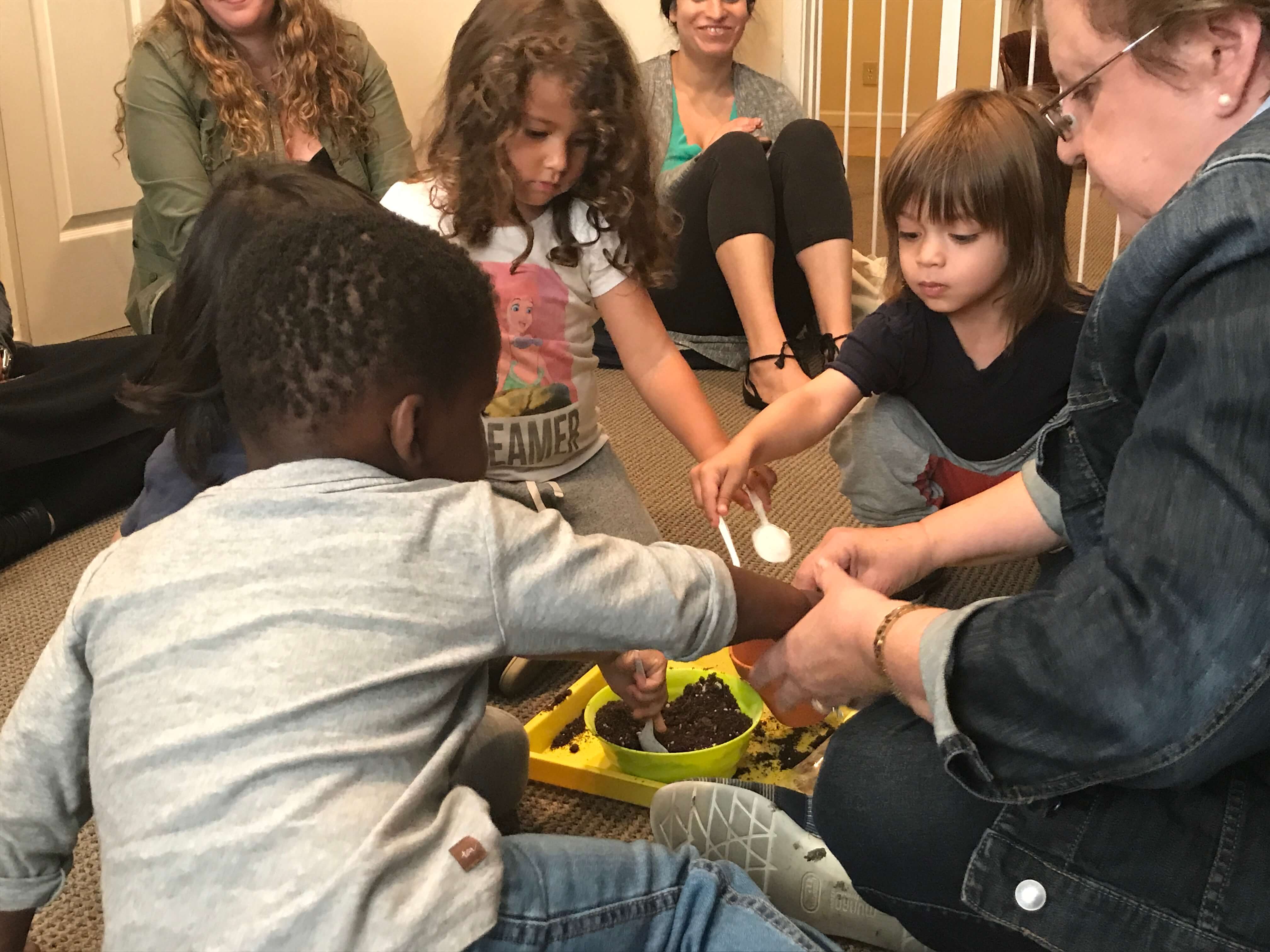 todddlers at Early Childhood Development Associates' class learning to plant pots