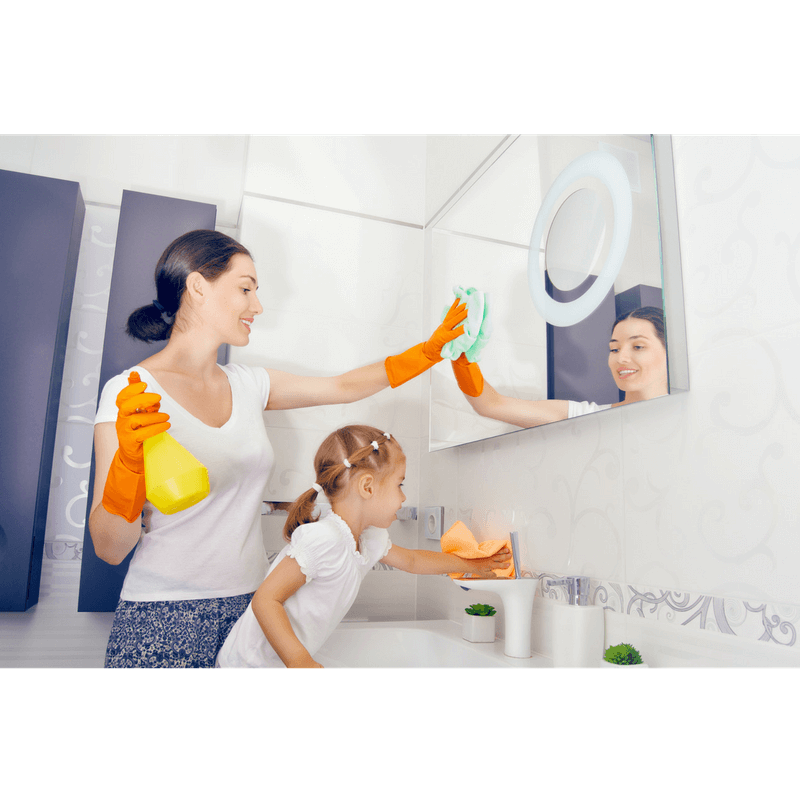 mom modeling how to clean mirror in the bathroom with toddler daughter