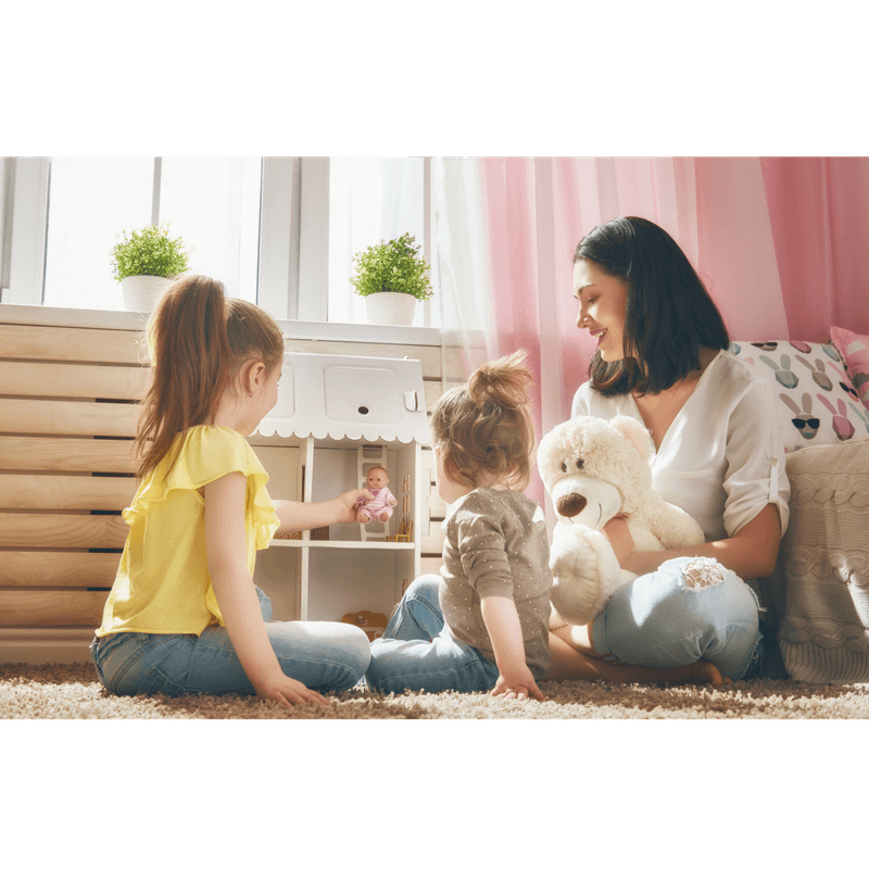 mother and 2 little girls playing doll house and talking
