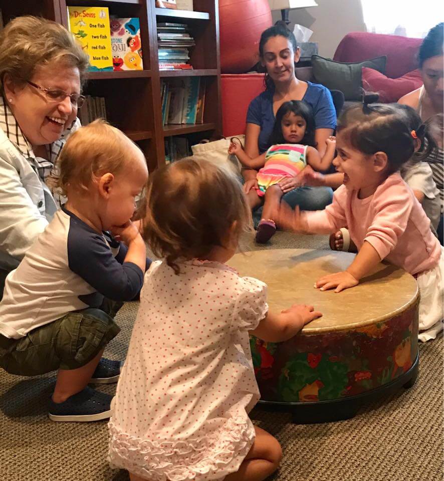 children playing the drum at Early Childhood Development Associates's class