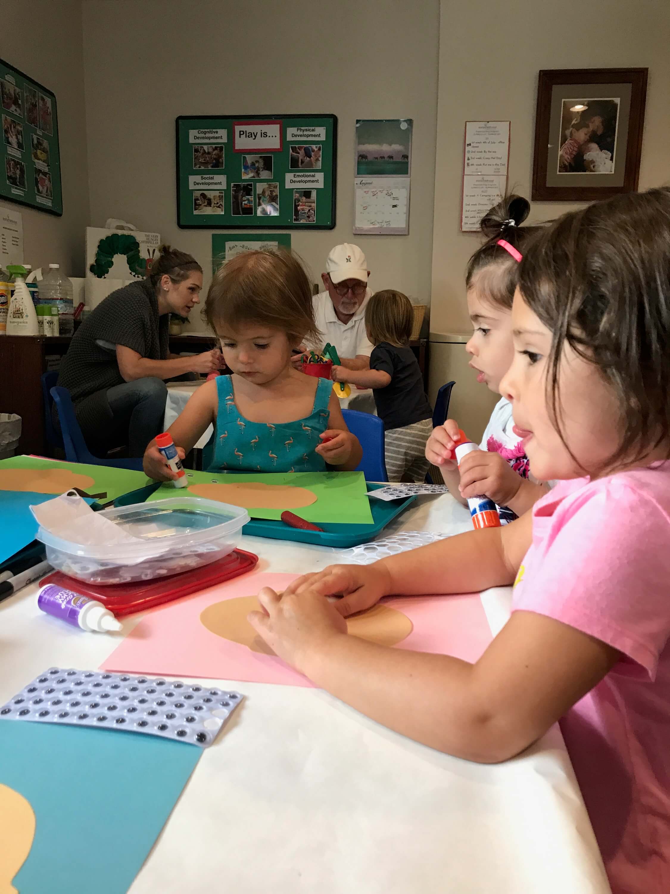 todder making faces out of paper at Early Childhood Development Associates' class