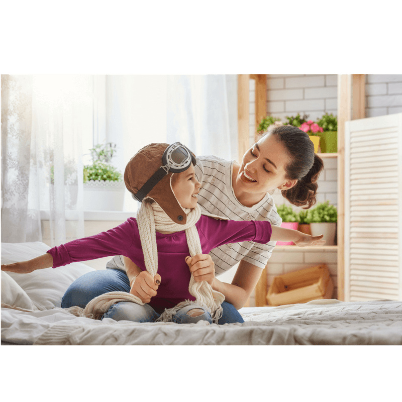 mom and toddler girl pretend playing dessing up for Halloween - girl is wearing a hat