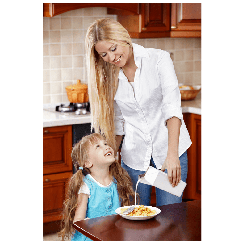 mom giving daughter cereal and mil before going to school in the morning