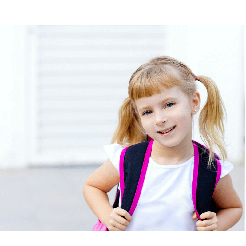 little girl looking happy wearing her backpack and ready to go to school in the morning