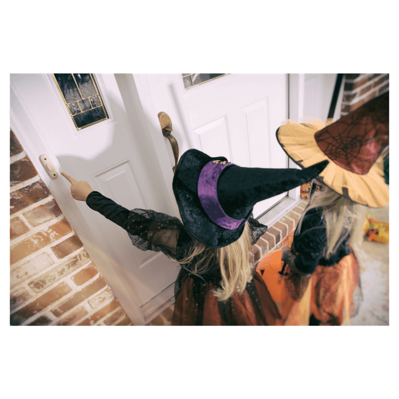 2 little toddler girls knocking at a door trick-or-treating wearing costumes